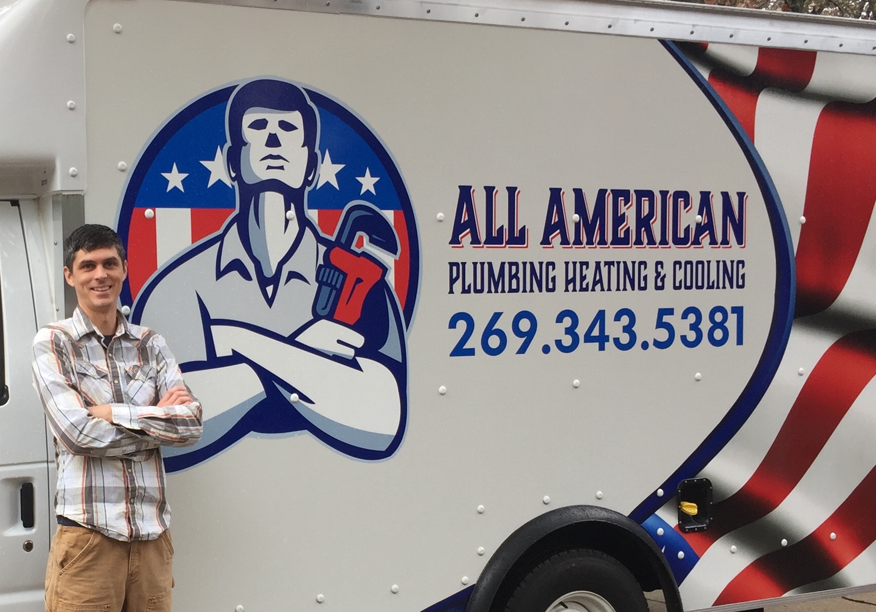 The owner of All American Plumbing Heating & Cooling posing in front of his truck