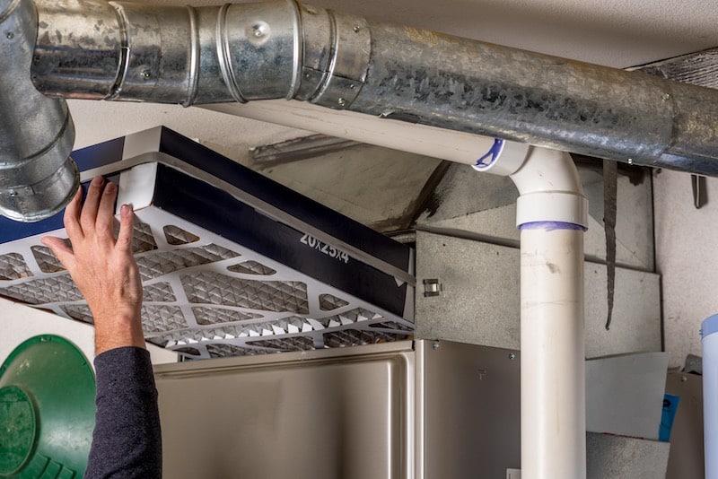 Handyman replaces a furnace filter with a clean one Furnace maintenance image