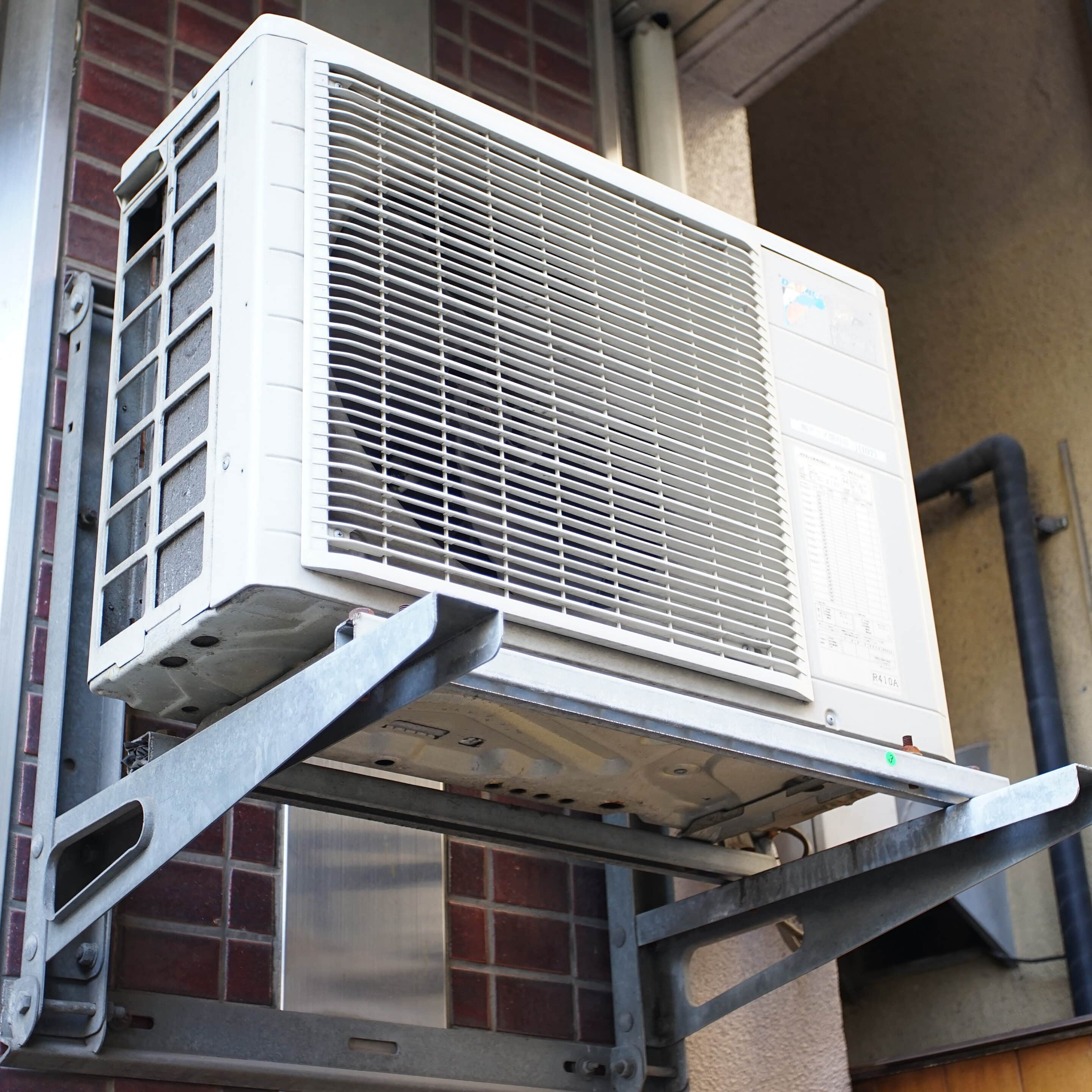 Outdoor air conditioning unit mounted on a tiled exterior wall